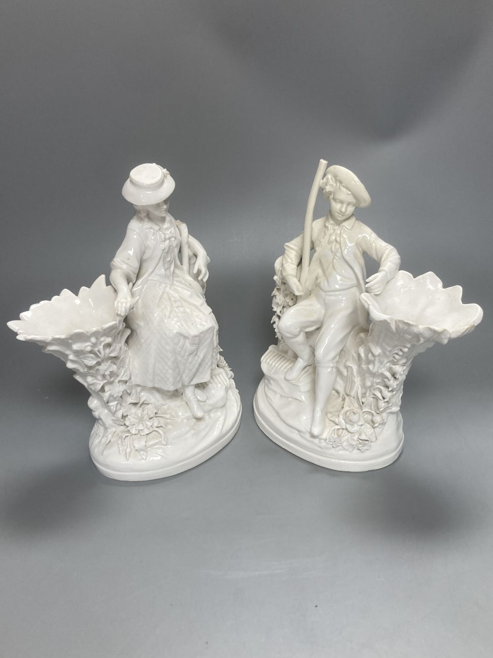 A pair of John Bevington bone china figures, gardener and female companion, 21.5cm